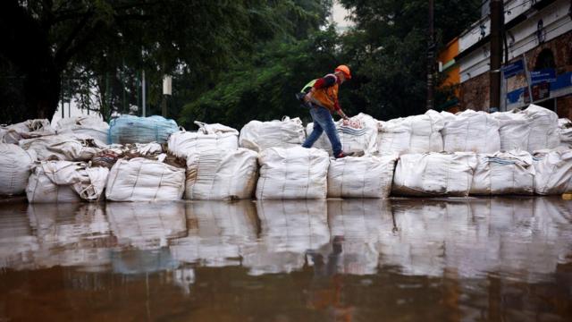 Homem em dique para conter a água